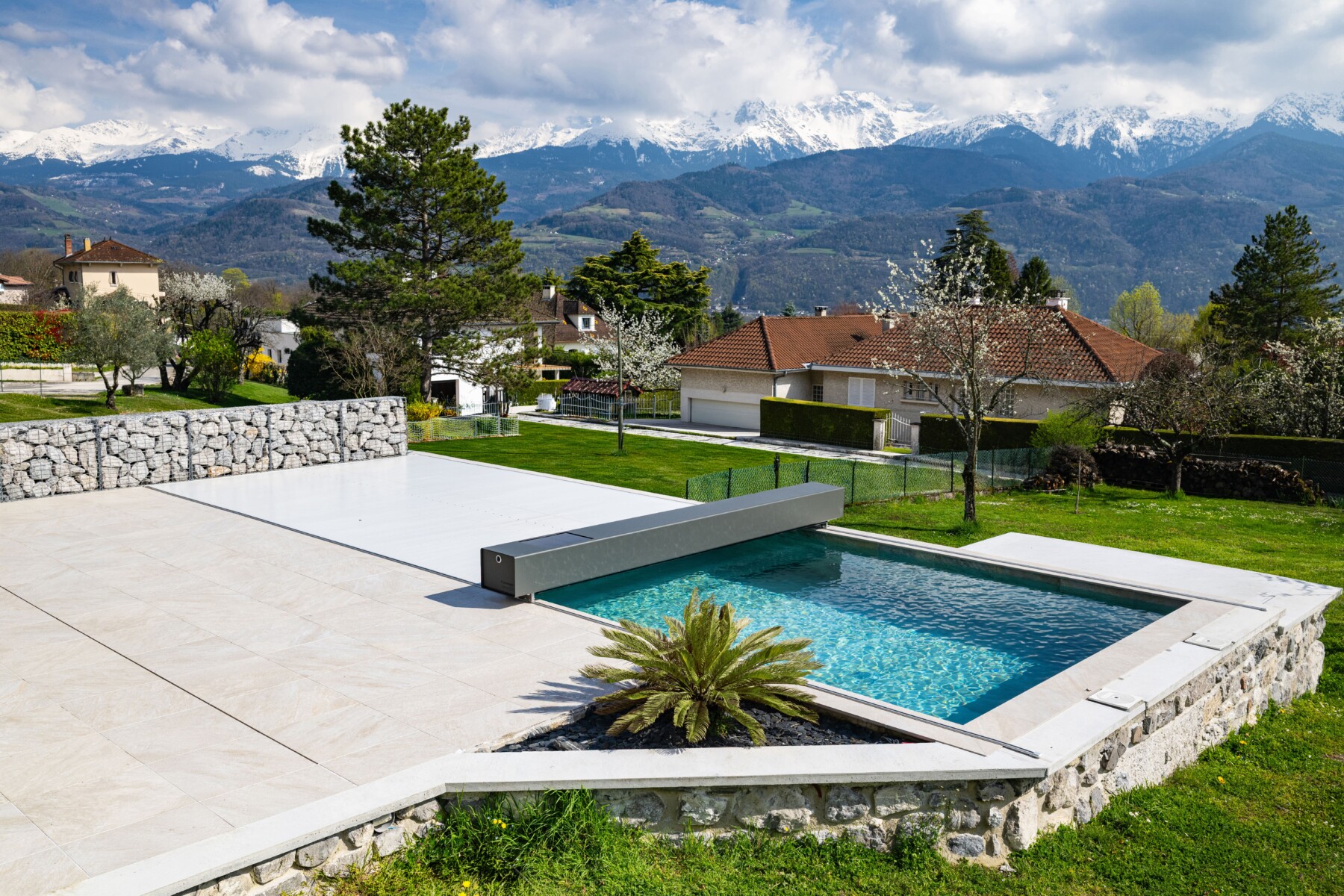 Piscine et terrasse avec couverture Coverseal dans un environnement de montagne.